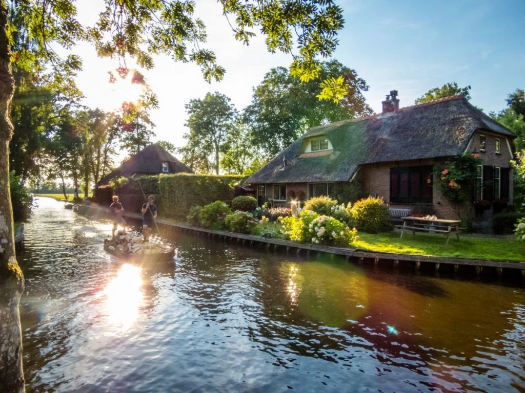 Jovens transportam lenha nos canais de Giethoorn usando o Gieterse punter, uma espécie de gôndola típica de Gietehoorn. O vilarejo é conhecido como a Veneza da Holanda.
